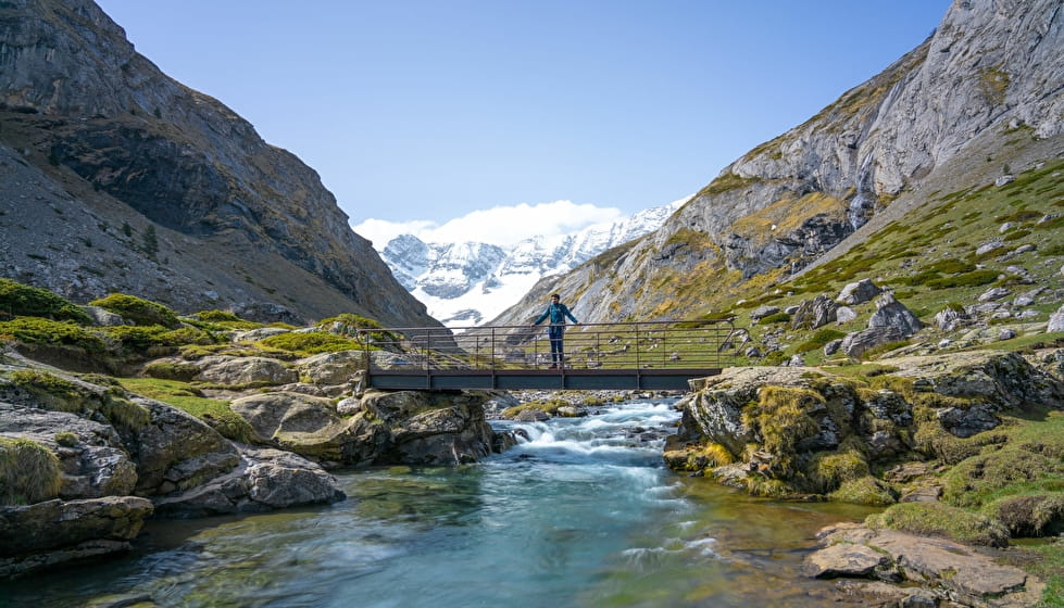 Cruzando el puente durante la caminata Cirque d'Estaubé en los Pirineos