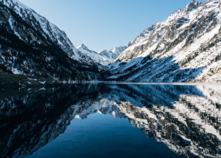 Reflections of snow-capped peaks on Lac de Gaube in Cauterets